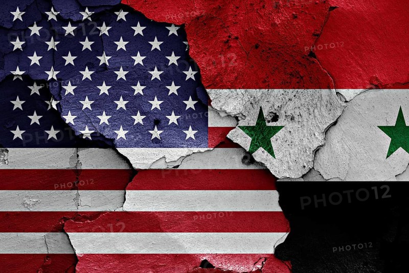 Flags of USA and Syria painted on cracked wall