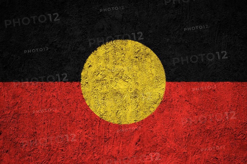 Australian Aboriginal flag painted on the cracked grunge concrete wall