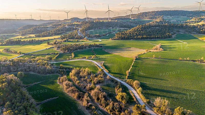 Aerial view of windmills on the hills between fields of cereal cultivation in the province of Tarragona in Catalonia in Spain