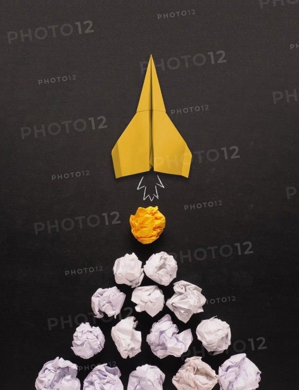 Launching paper rocket with jet stream of paper balls, creativity concept or new ideas metaphor, start up business, new year?s resolution