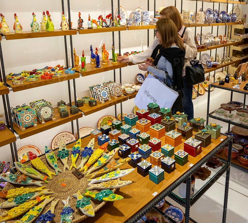 Shopping inside tourist souvenir craft shop selling pottery and ceramics, Guimaraes, northern Portugal
