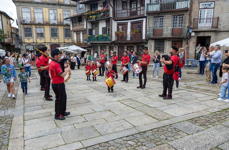Traditional drum and pipe band perform on city streets on May Day 2025, Guimaraes, Braga district, northern Portugal