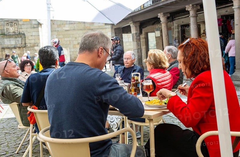 Customers sittimg outside at cafe tables, Largo da Oliveira square, city of Guimaraes, northern Portugal