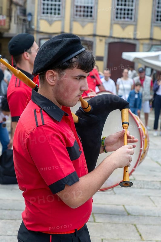 Traditional piper in band performing on city streets on May Day 2025, Guimaraes, Braga district, northern Portugal