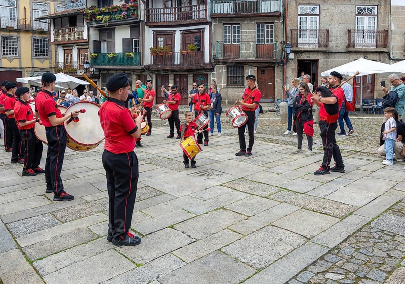Traditional drum and pipe band perform on city streets on May Day 2025, Guimaraes, Braga district, northern Portugal