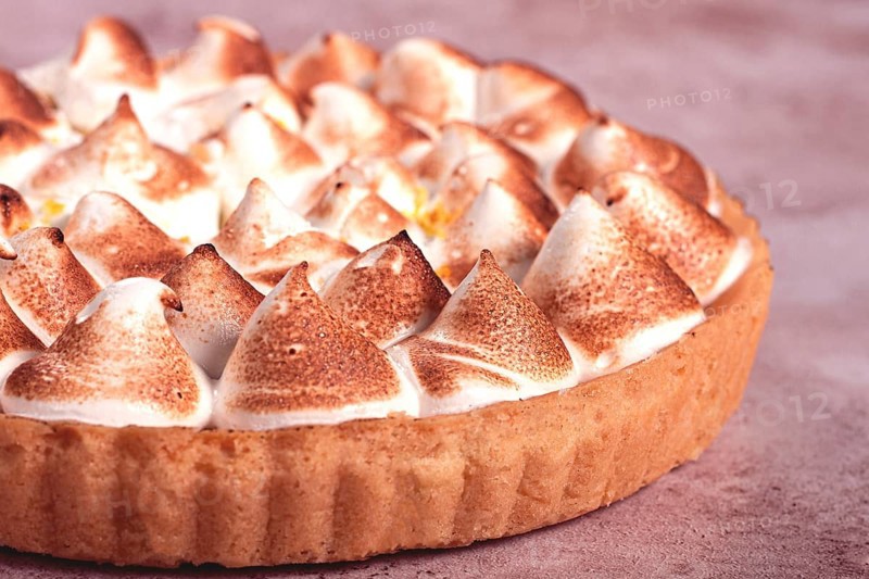Lemon meringue cake, golden brown, toasted, on a light table, no people
