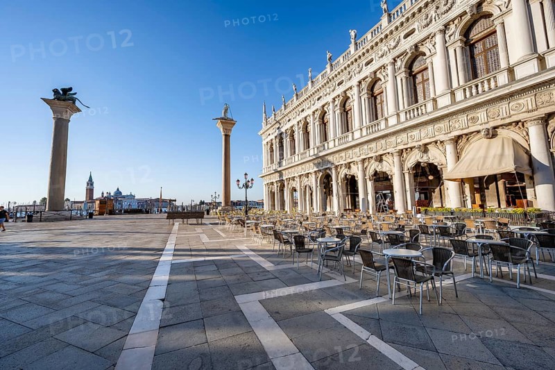 Chairs and tables of cafes at Piazetta San Marco, Colonna di San Marco and Colonna di San Todaro, in the morning light, St Mark's Square, Venice, Veneto, Italy, Europe