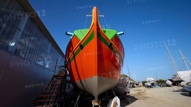 Large orange boat in a shipyard in front of a blue sky, boatyard Diakofti, new construction of a coloured wooden boat, Diakofti, Patmos, Dodecanese, Greek Islands, Greece, Europe