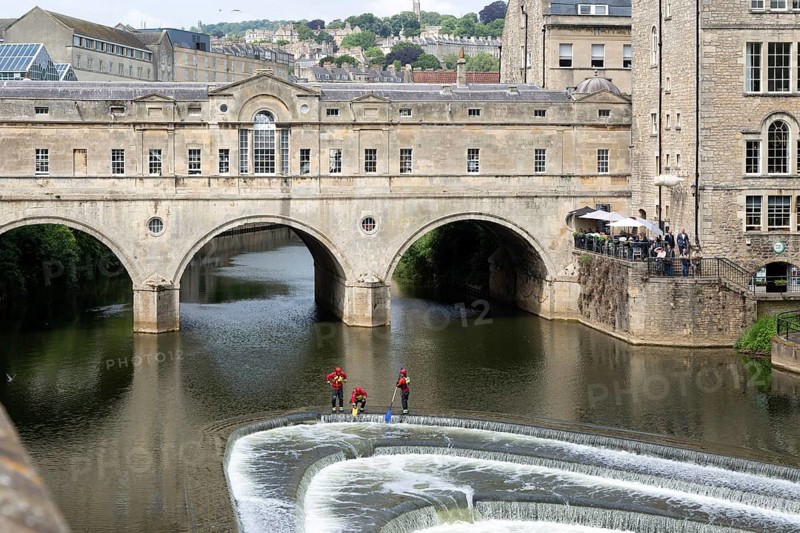 Avon Fire and Rescue Service personnel on weir on River Avon, Pulteney Bridge, city of Bath, north east Somerset, England, UK