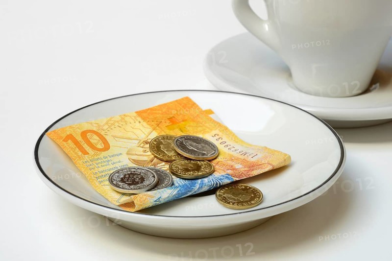 Tip, Swiss coins and Swiss franc note on plate, Switzerland, Europe