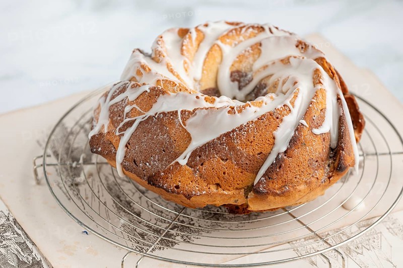 Marble bundt cake, cake with icing on a cake rack, light background