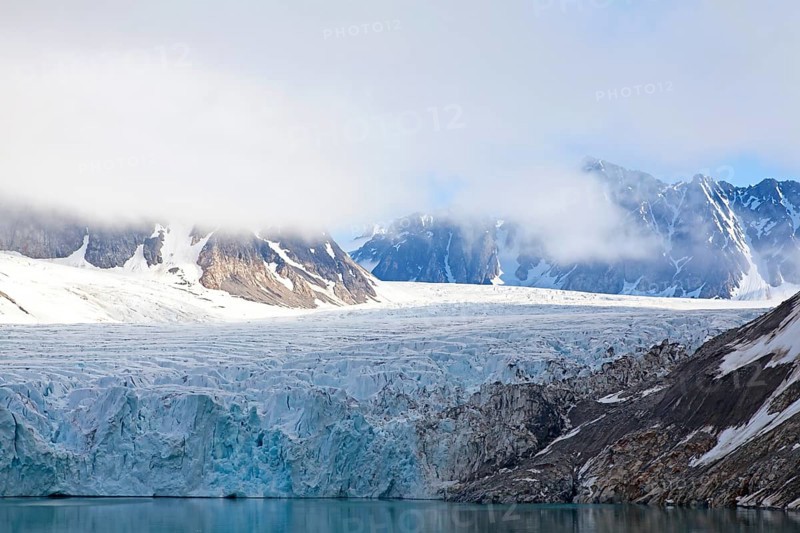A fascinating glacier with snow-covered mountains and clouds creating a calm and peaceful atmosphere, Magdalenenfjord with Waggonway Glacier, Svalbard, Norway, Europe