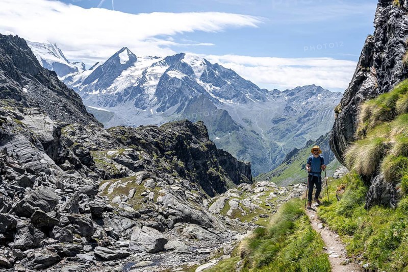 Mountaineer on hiking trail in mountain landscape, descent at Col du Louvie, view of the summit of the Grand Combine, Valais Alps, Val de Bagnes, Valais, Switzerland, Europe