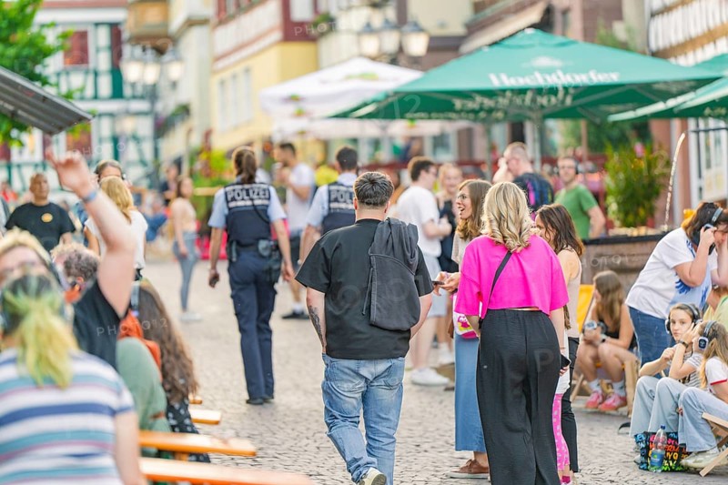 Street scene with people and policemen during a summer entertainment in the city, railway station festival Calw, Black Forest, Germany, Europe