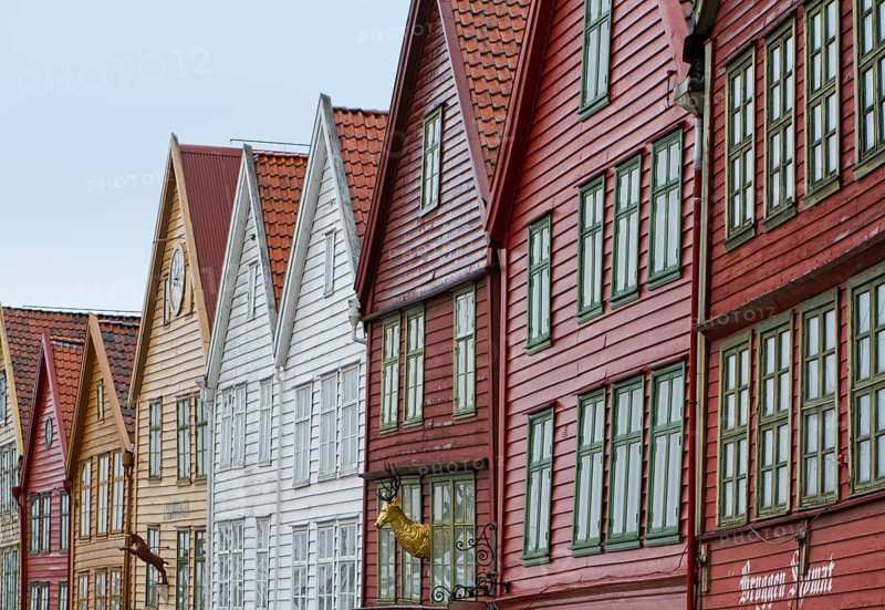 Row of colourful wooden houses with red roofs and rows of windows in Scandinavian style, Bergen, Norway, Europe