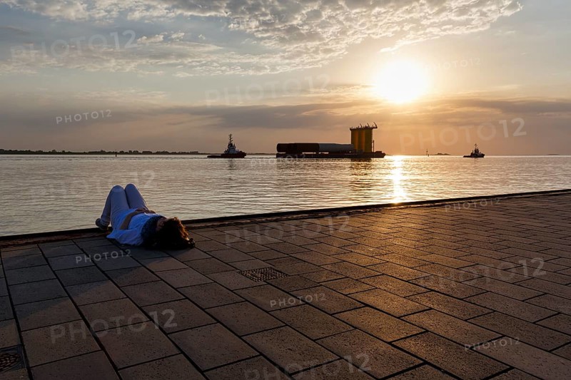 Tourist enjoying the view, sunset on the Weser, pier Seebäderkaje, pontoon, Willy-Brandt-Platz, Havenwelten, Bremerhaven, Bremen, Germany, Europe