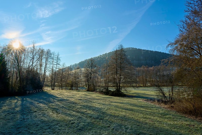 The sky illuminates a meadow and trees in front of a wooded hill, Kirchzell, Amorbach, Odenwald, Bavaria, Germany, Europe