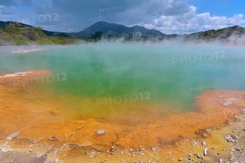 A geothermal area with steaming water and blue skies, Champagne Pool thermal lake, Wai-O-Tapu Thermal Wonderland, Rotorua, North Island, New Zealand, Oceania