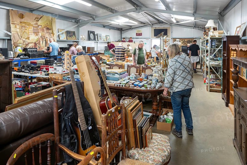 People at auction viewing inside auction room of household clearance lots, Suffolk, England, UK