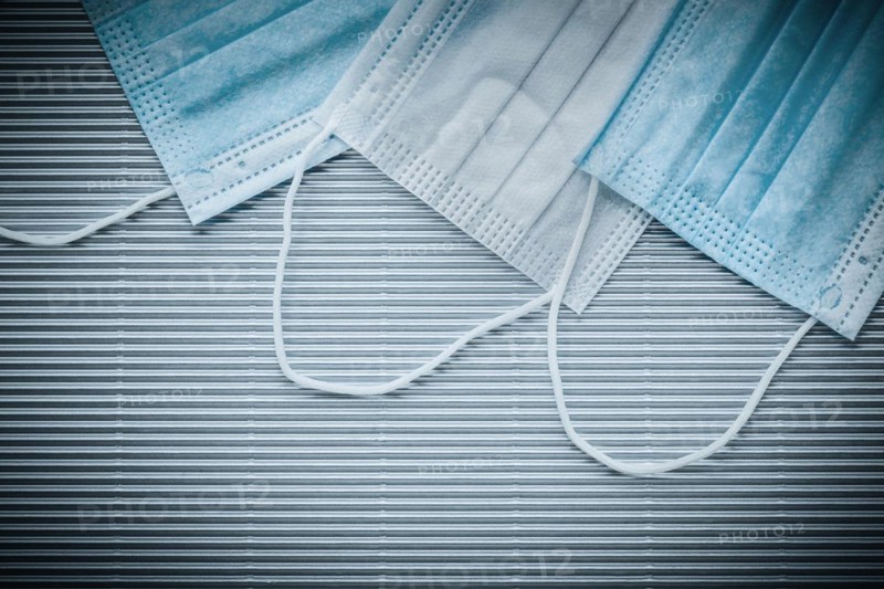 Medical disposable sterile masks on striped background top view