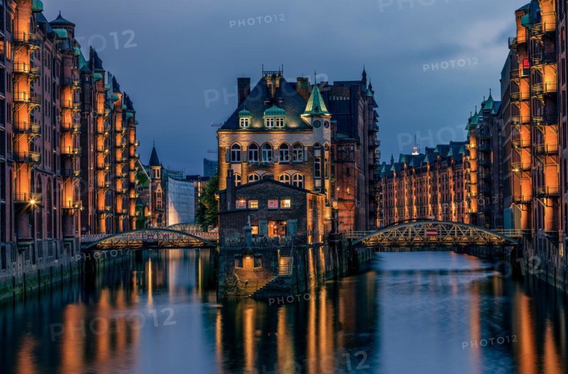 View of the Speicherstadt at night in Hamburg, Germany. Illuminated Speicherstadt seen from the Poggenmühlen Bridge