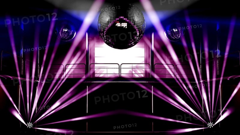 Night club interior with colorful spot lights, lasers and shining mirror disco balls artistic light show