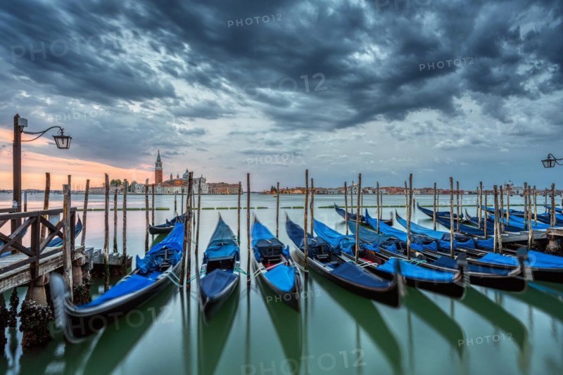 Gondolas on St Mark's Square in Venice, Italy, during a dramatic sunrise, Europe