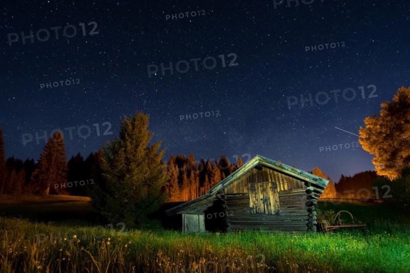 Wooden barn under a nigth sky full of stars