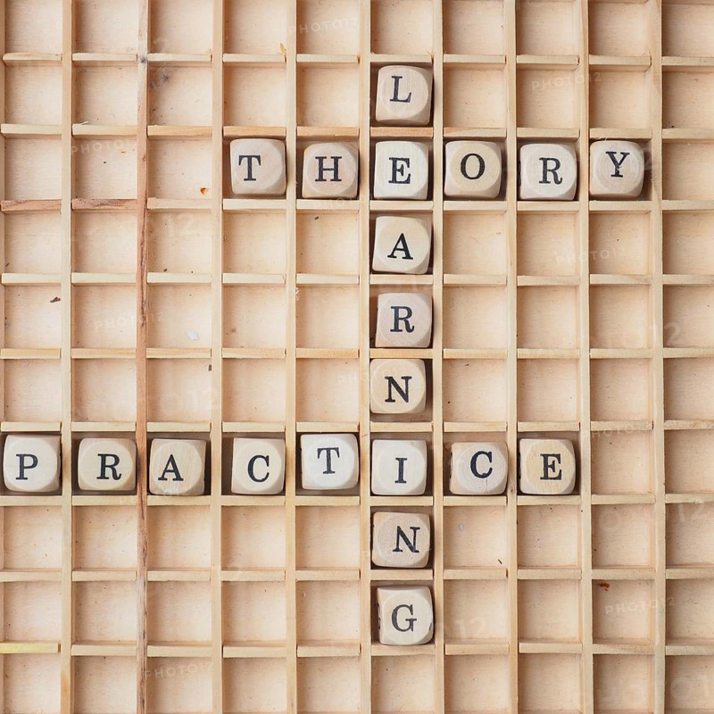 Learning concept with wooden dices and the words theory and practice