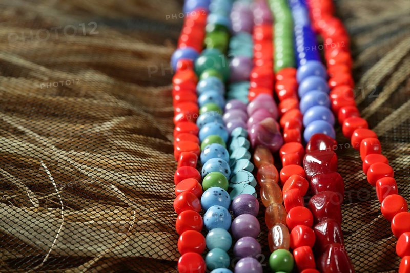 Color stones jewelry necklaces over natural straw and tulle background