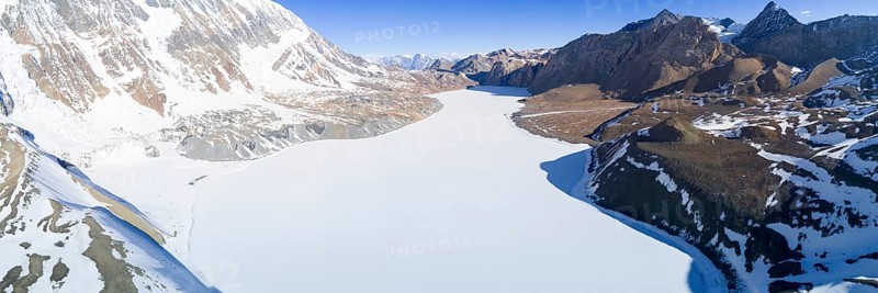 Aerial view of high altitude Tilicho Lake frozen and covered with snow in the Himalaya mountains of Nepal