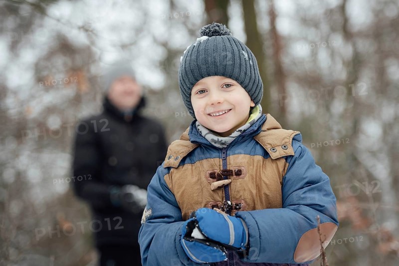 Six year old boy smiling during makeing snowball