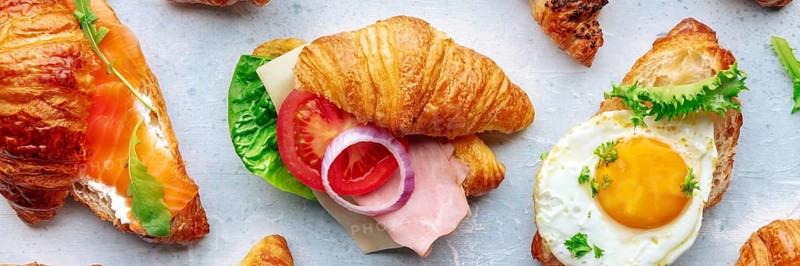 Croissant sandwich variety panorama. Different stuffed croissants, overhead flat lay shot. Rolls filled with ham, salmon, egg, etc, Food photography, Food photography