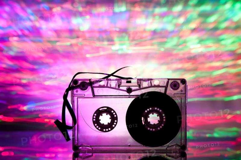 Cassette tape and multicolored pink blue lights on background