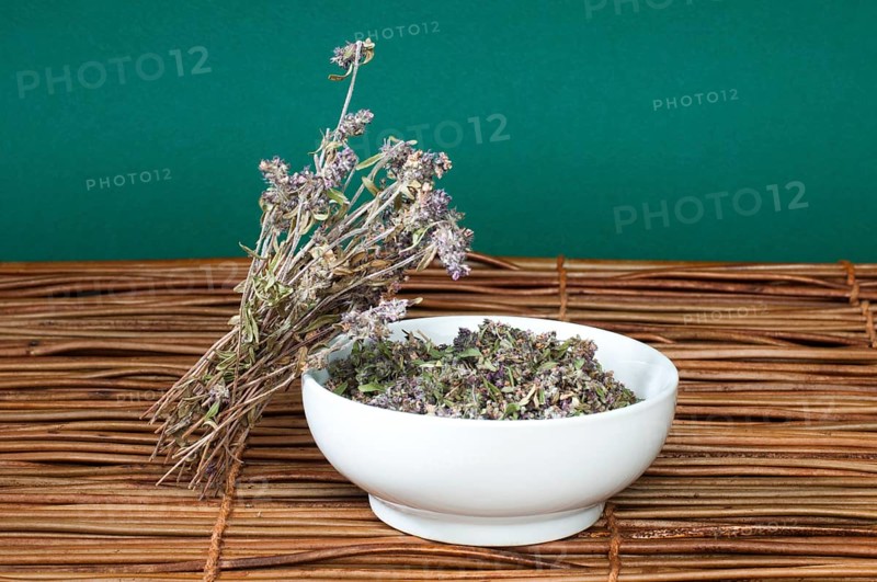Dried thyme in a bowl on a wooden base