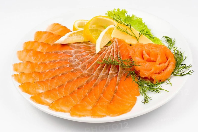 Sliced smoked salmon served with lemon and salmon rose