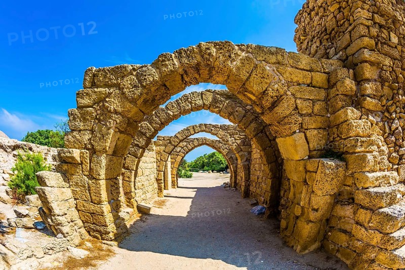 Excursion to the Archaeological Park of the Roman Empire. Arched passage - covered street of Port of Caesarea. Sunny spring day. Israel. Concept of ecological and historical tourism