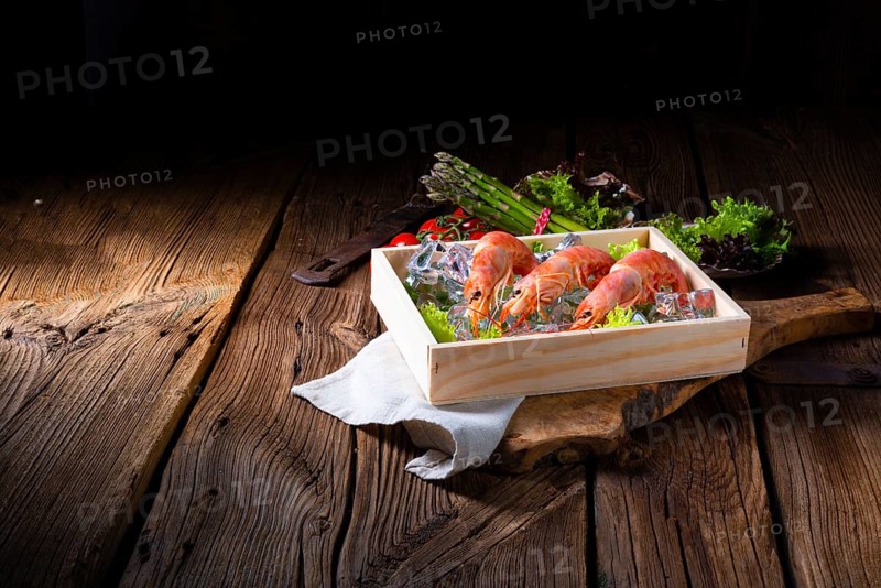 Cooked argentine red prawns with salad on the ice