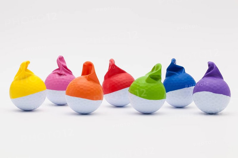 White golf balls with funny caps on the white background. Funny golf concept