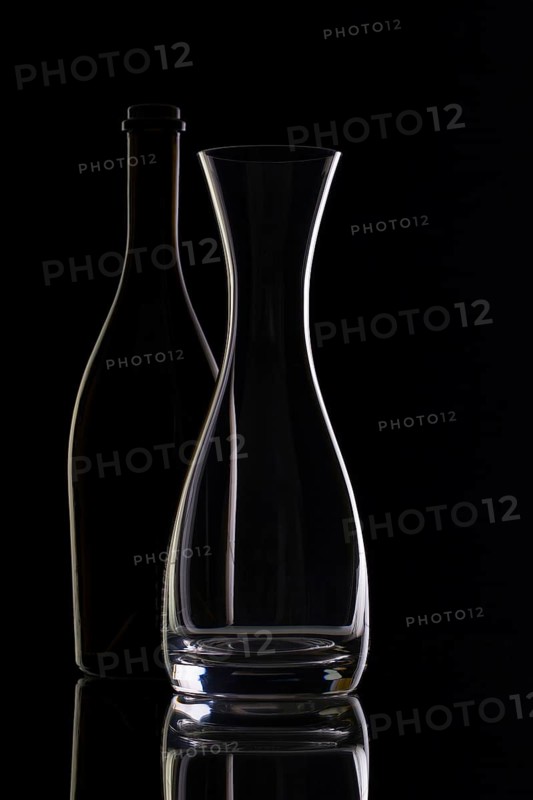 Empty glass and bottles on the black background