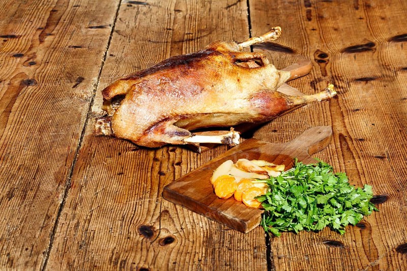Roasted goose on wooden table