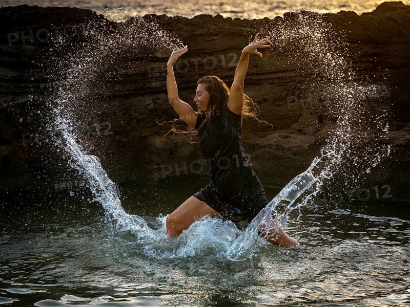 Middle-aged woman dancing and throwing water in the air, Maioris beach, llucmajor, Majorca, Balearic Islands, Spain, Europe