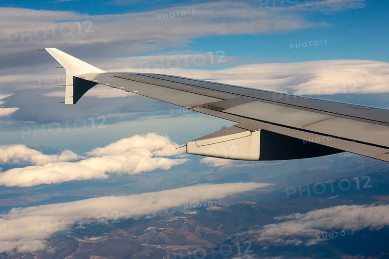 Airplane during flight with the sky and clouds on the background