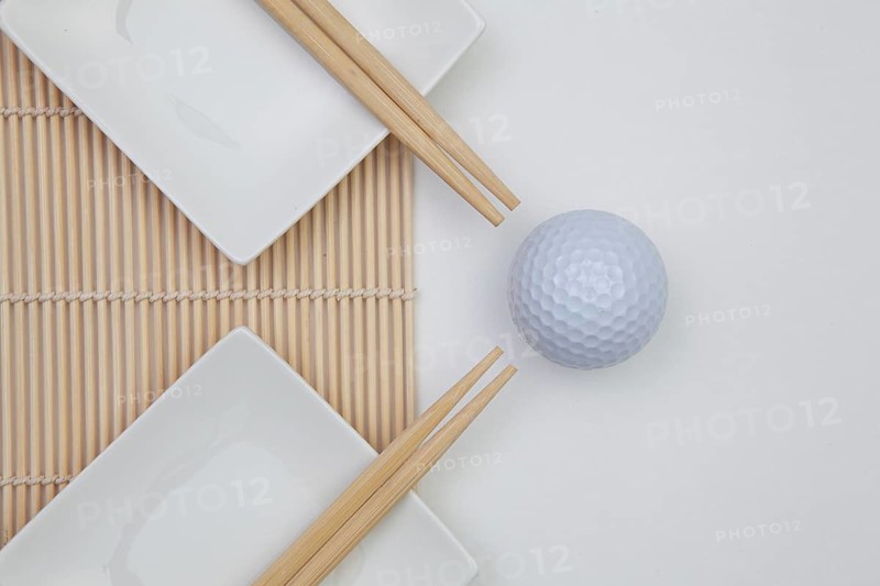 Top View Of White Empty Sushi Plates With Bamboo Chopsticks and Golf Ball. Golf Design