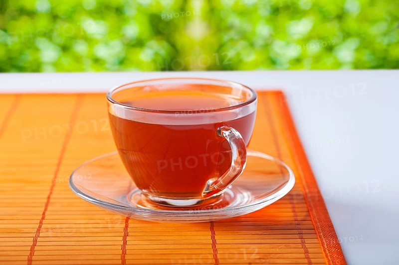 Transparent cup with tea on table