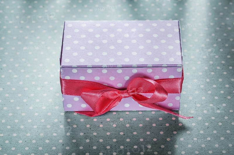 Pink present box on blue polka-dot tablecloth holidays concept