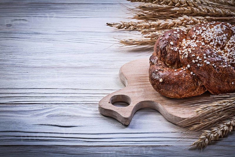 Chopping board wheat rye ears bread stick on wooden background