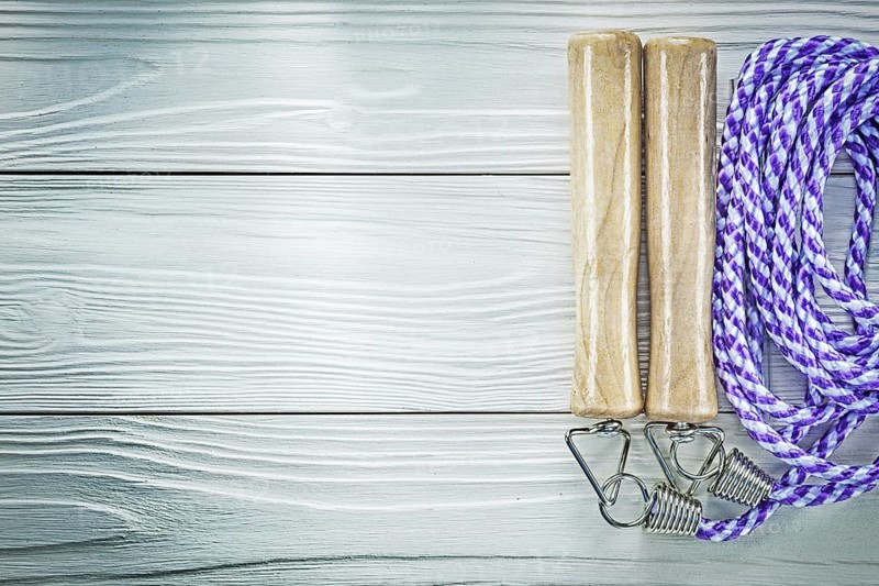 Jump rope on wooden board copy space sports training concept