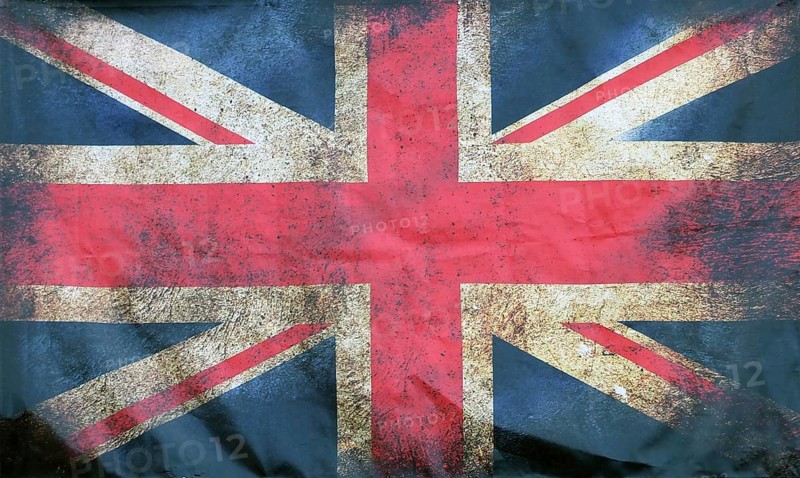 A full frame image of an old stained dirty union jack british flag with dark crumpled edges