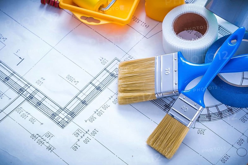Blueprint with paint roller tray brushes bottle duct tape and wooden meter copy space image construction concept